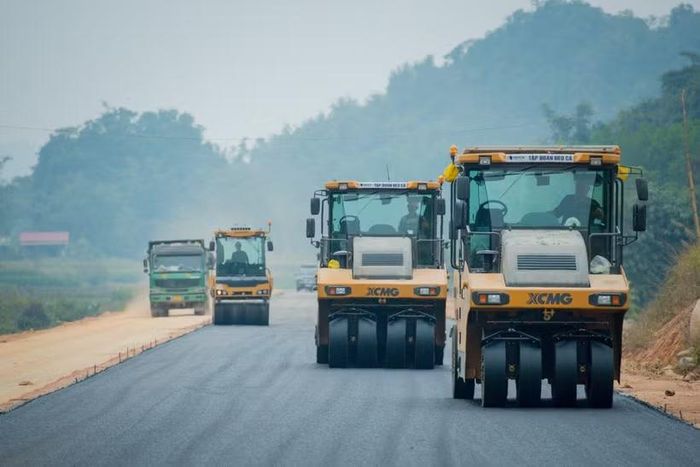 Nhà thầu thi công thảm nhựa nền đường một dự án đường bộ cao tốc. (Ảnh: PV/Vietnam+)
