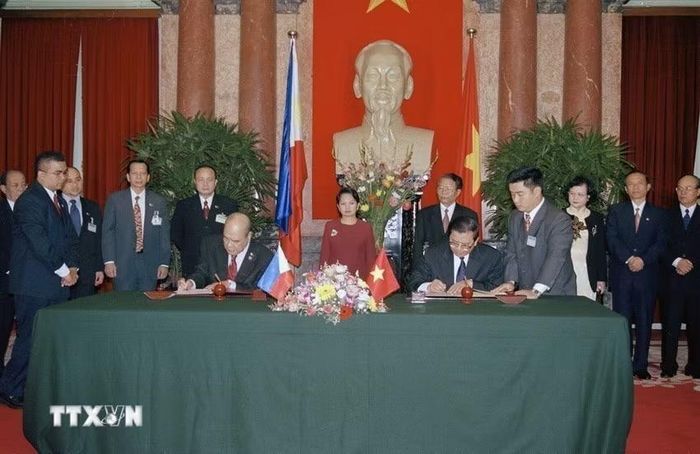 Chủ tịch nước Trần Đức Lương và Tổng thống Philippines G. M. Arroyo chứng kiến lễ ký kết văn kiện hợp tác giữa hai nước (Hà Nội, 2002). (Ảnh: Nhan Sáng/TTXVN)