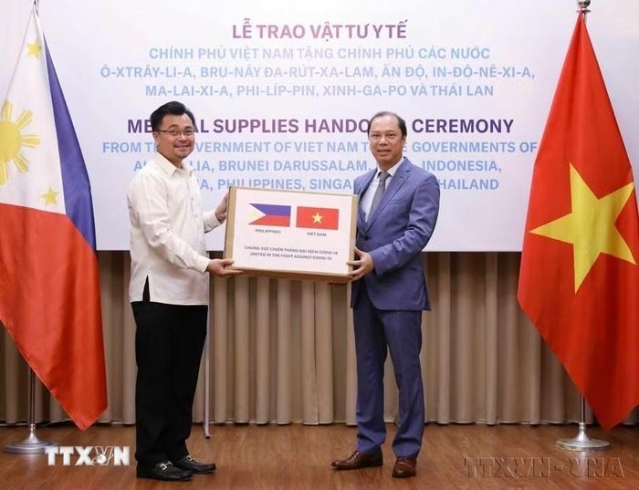 Thứ trưởng Bộ Ngoại giao Nguyễn Quốc Dũng trao tượng trưng hỗ trợ của Chính phủ và nhân dân Việt Nam cho Chính phủ và nhân dân Philippines trong phòng, chống dịch COVID-19 (Hà Nội, 18/5/2020). (Ảnh: Văn Điệp/TTXVN)