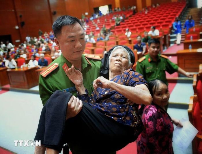 Lực lực lượng công an xã Hoàng Vân hỗ trợ thân nhân liệt sỹ đến thu mẫu phục vụ xác định danh tính liệt sỹ. (Ảnh: Danh Lam/TTXVN)