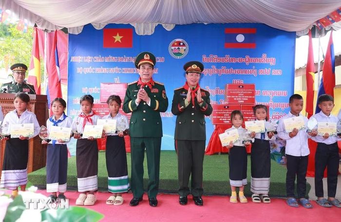 Hai Phó Thủ tướng, Bộ trưởng Quốc phòng tặng quà học sinh Trường Tiểu học Thongnammoun. (Ảnh: Trọng Đức/TTXVN)