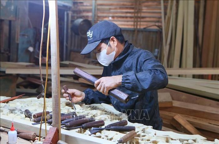 Thợ đục tại Làng nghề đồ gỗ thôn Đằng Chương, xã Vạn Thắng hoàn thiện sản phẩm.