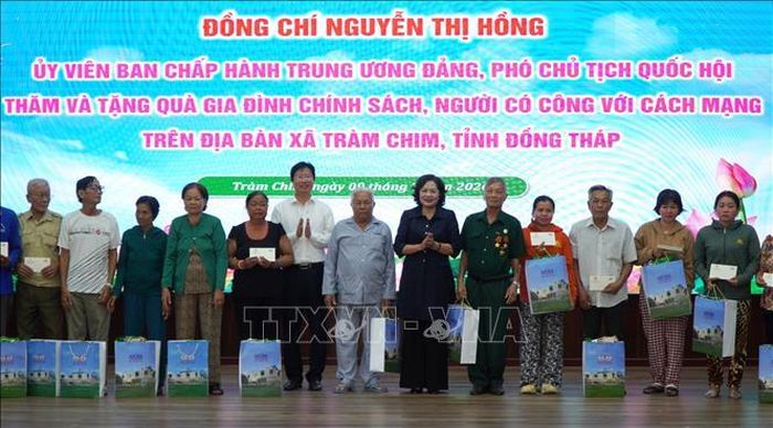 Phó Chủ tịch Quốc hội Nguyễn Thị Hồng tặng quà cho gia đình có công với cách mạng ở xã Tràm Chim, tỉnh Đồng Tháp. Ảnh: Nhựt An/TTXVN.