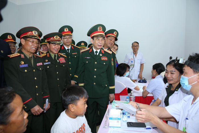 Đại tướng Phan Văn Giang và Đại tướng Khăm Liêng - Ụ Thạ Cay Sỏn cùng Đoàn công tác Bộ Quốc phòng hai nước động viên lực lượng Quân y đang thăm khám và phát thuốc miễn phí cho nhân dân biên giới trong Chương trình Giao lưu hữu nghị Quốc phòng biên giới Việt Nam - Lào lần thứ 3.