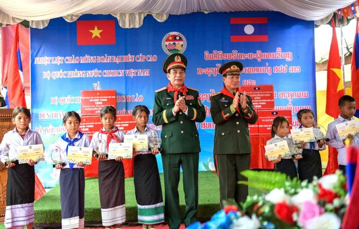 Đại tướng Phan Văn Giang - Ủy viên Bộ Chính trị, Phó Thủ tướng Chính phủ, Bộ trưởng Bộ Quốc phòng Việt Nam và Đại tướng Khăm Liêng - Ụ Thạ Cay Sỏn, Ủy viên Bộ Chính trị Ban Chấp hành Trung ương Đảng Nhân dân Cách mạng Lào, Phó Thủ tướng Chính phủ, Bộ trưởng Bộ Quốc phòng Lào trao tặng học bổng cho các em học sinh.