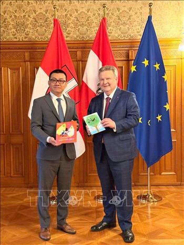 Đại sứ trao tặng Thị trưởng Ludwig cuốn sách văn học thiếu nhi được dịch sang tiếng Việt “Bà Ngoại trên cây táo” của nhà văn Áo nổi tiếng Mira Lobe. Ảnh: TTXVN phát