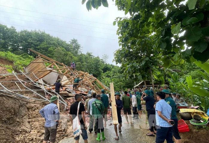 Cán bộ, chiến sĩ lực lượng công an, quân đội và các tổ chức đoàn thể cùng nhân dân xã Mường Sại, tỉnh Sơn La tham gia hỗ trợ gia đình Lò Văn Tuyến di dời tài sản do nhà bị đổ sập gây ra bởi sạt lở taluy dương. Ảnh: TTXVN phát 