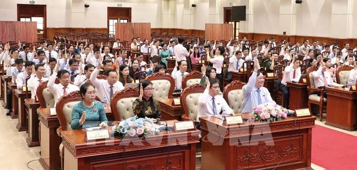 Các đại biểu biểu quyết thông qua dự thảo Nghị quyết HĐND tỉnh Đồng Tháp. Ảnh: Hồng Nhung - TTXVN