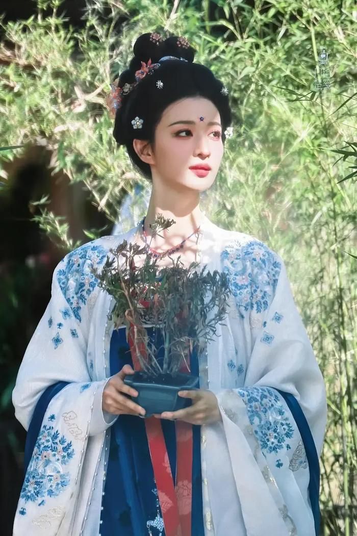 Vương Sở Nhiên diện áo khoác trắng thêu hoa xanh bên ngoài, phối cùng váy xanh đậm và dải lụa đỏ phía trước. (Ảnh: Sohu)