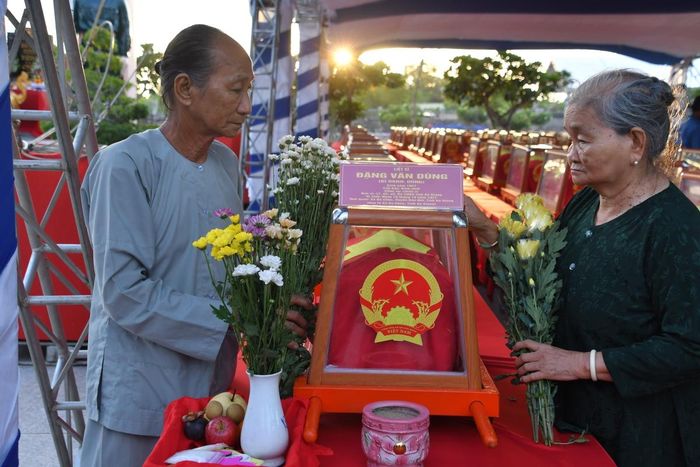 Bà Đặng Thị Bé (chị ruột) và ông Đặng Văn Hùng (anh ruột) của liệt sĩ Đặng Văn Dừng (Dũng) bên hài cốt liệt sĩ do Đội K93 tìm kiếm, quy tập và xác định danh tính.