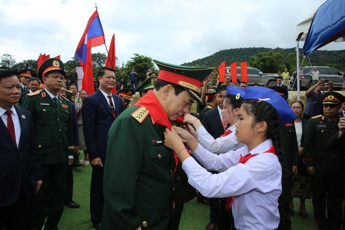 Đại diện học sinh tiểu học Thông-năm-mun, tỉnh Bolikhamxay, Lào vinh dự quàng khăn đỏ cho Đại tướng Phan Văn Giang. Ảnh: Nam Trần