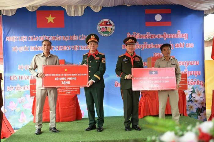 Đại tướng Phan Văn Giang và Đại tướng Khamliang Outhakaysone trao tặng nhà trường nhiều phần quà phục vụ công tác dạy và học, đồng thời trao 100 suất học bổng cho học sinh có hoàn cảnh khó khăn. Ảnh: Nam Trần