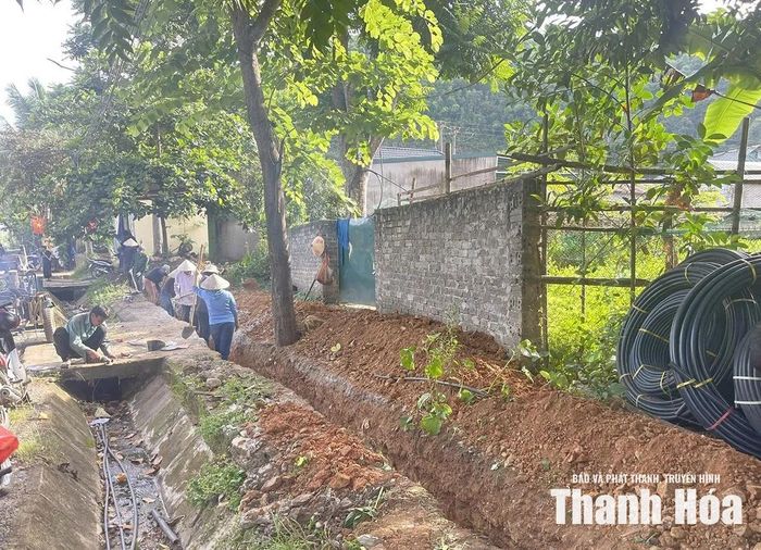 Công nhân thi công lắp đường ống dẫn nước trên địa bàn xã Quan Sơn.