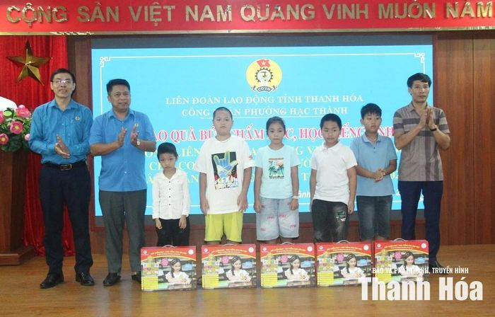 Điện lãnh đạo Liên đoàn Lao động tỉnh và phường Hạc Thành trao quà cho các em học sinh.