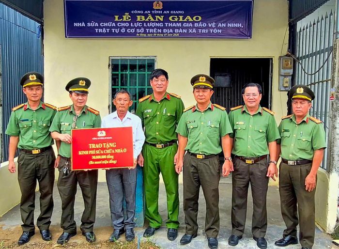 Trao bảng tượng trưng kinh phí hỗ trợ sửa chữa nhà cho gia đình ông Lê Văn Út (áo trắng).