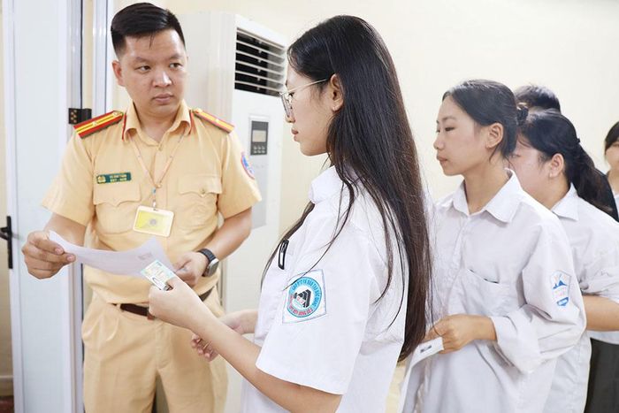  Cán bộ Phòng Cảnh sát giao thông kiểm tra thông tin cá nhân của học viên trước khi vào làm bài thi lý thuyết sát hạch giấy phép lái xe mô tô trên máy tính. 