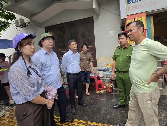 Ông Lê Quý Việt - chủ các căn nhà đang tháo dỡ (ngoài cùng bên phải) trao đổi vụ việc với cán bộ chức năng.
