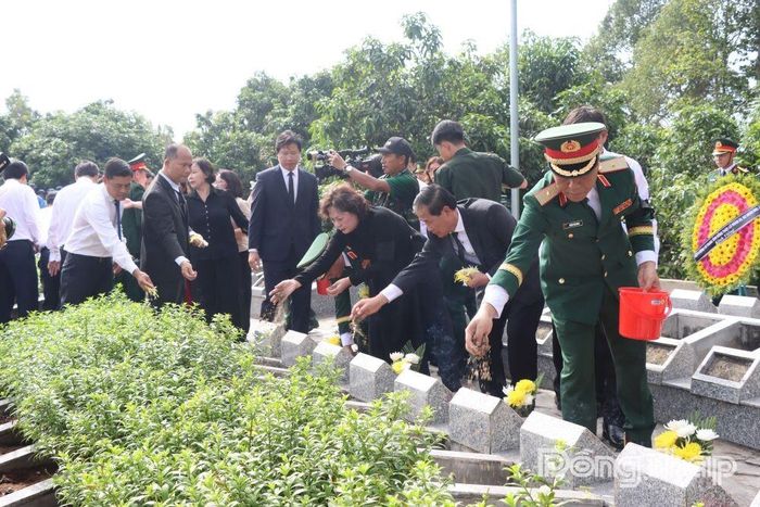 Những nắm đất đầu tiên được các đại biểu thành kính vun lên phần mộ các liệt sĩ.