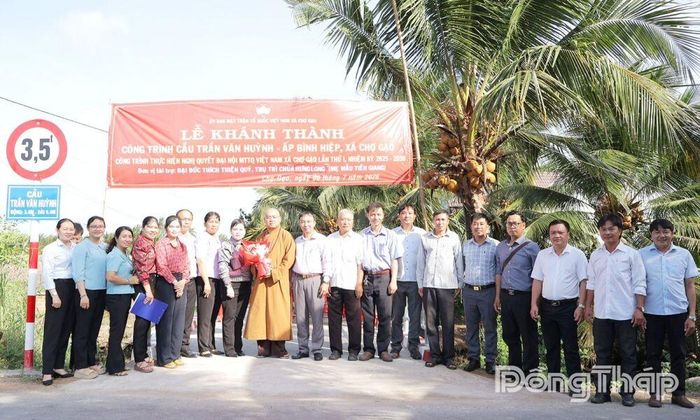 Các đại biểu chụp ảnh lưu niệm tại buổi khánh thành cầu Trần Văn Huỳnh tại ấp Bình Hiệp.