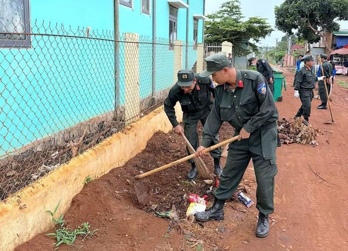  Cán bộ, chiến sĩ Tiểu đoàn 1 dọn vệ sinh tại điểm trường học ở xã Ia Băng. Ảnh: H.P 