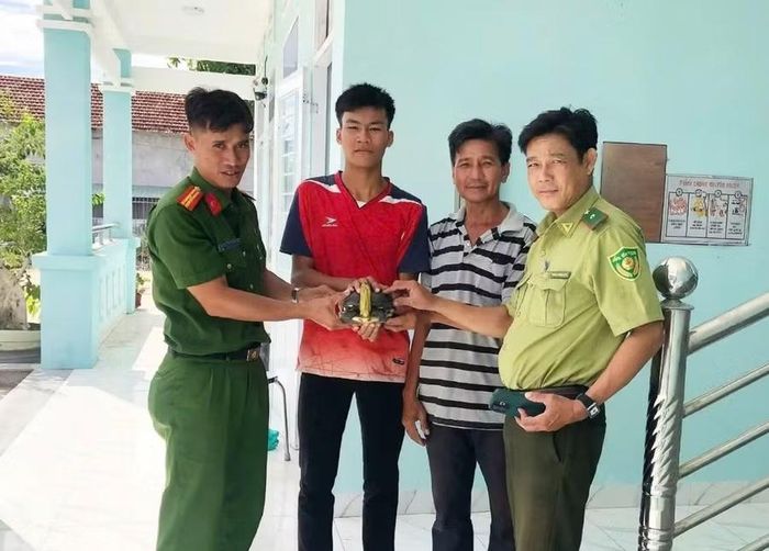 Em Phan Hùng Vương (thứ 2 từ trái sang) giao nộp cá thể rùa cổ sọc cho cơ quan chức năng. Ảnh: ĐVCC