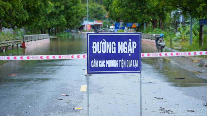 Lực lượng chức năng cắm biển cảnh báo khu vực bị ngập sâu.