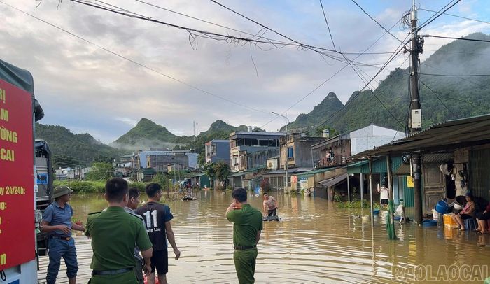 Cán bộ, chiến sĩ công an xã, lực lượng an ninh, trật tự cơ sở hỗ trợ người dân thôn Na Đẩy di dời tài sản ra khỏi khu vực ngập lụt.