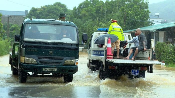 Lực lượng chức năng có mặt kịp thời hỗ trợ người dân di chuyển an toàn qua vùng ngập úng.