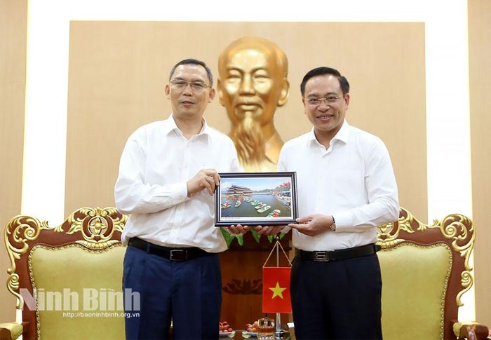 Đồng chí Đặng Thanh Sơn, Ủy viên Ban Thường vụ Tỉnh ủy, Phó Chủ tịch UBND tỉnh tặng quà lưu niệm cho Ngài Keovisouk Solaphom, Thứ trưởng Bộ Công nghệ và Truyền thông Lào.