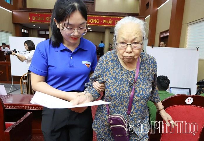 Lực lượng thanh niên tình nguyện hỗ trợ các thân nhân liệt sĩ đến điểm thu nhận mẫu ADN.