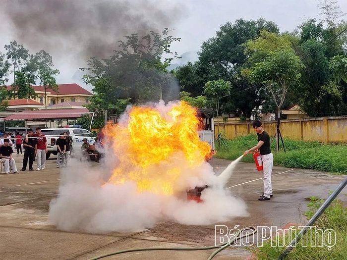 Học sinh Trường THPT Kim Bôi thực hành sử dụng bình chữa cháy xách tay dập lửa.