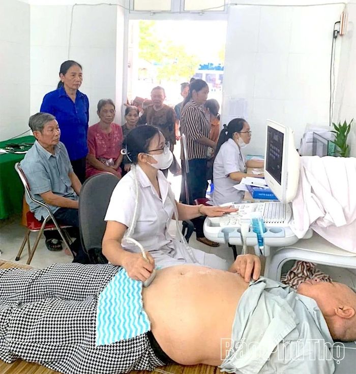 Bác sĩ Trạm y tế xã sử dụng máy siêu âm kiểm tra sức khỏe cho người cao tuổi.