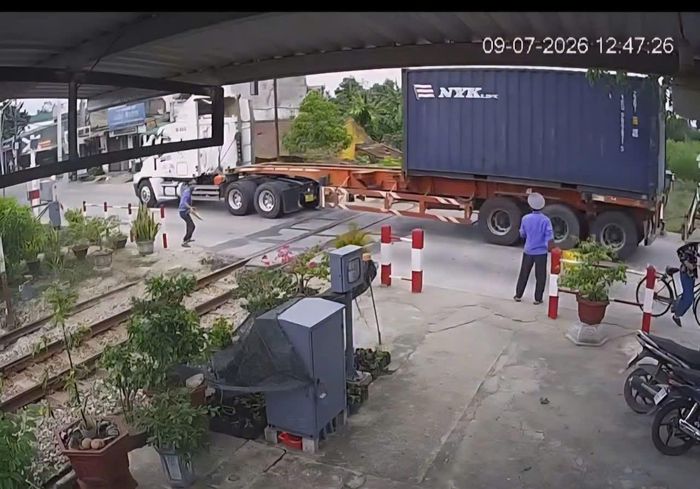 Hình ảnh xe đầu kéo cố tình vượt qua đường sắt khi thanh gác chắn đang hạ và nhân viên trực canh ra hiệu dừng.