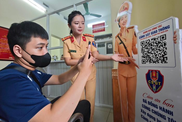 Người dân quét mã QR đánh giá chất lượng phục vụ khi đến làm việc tại cơ quan CSGT