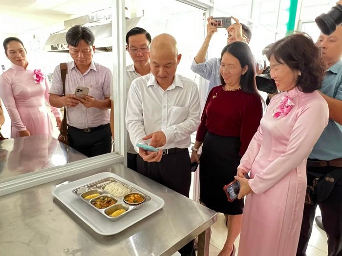 Ông Nguyễn Nguyên Phương, Phó giám đốc Sở Công thương TP Hồ Chí Minh cùng lãnh đạo phường Tân Mỹ và Hiệu trưởng Trường Mầm non Phú Mỹ kiểm tra nguồn gốc thực phẩm bữa ăn của học sinh qua mã quét QR.