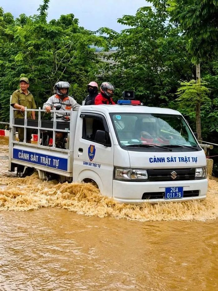 Công an xã Quỳnh Nhai hỗ trợ nhân dân di chuyển qua một số điểm ngập sâu.