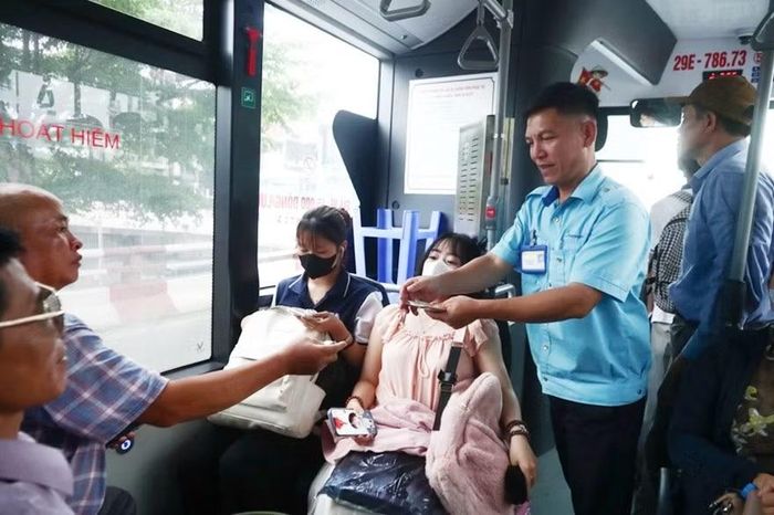 Nhân viên niềm nở hỗ trợ hành khách trên xe buýt.