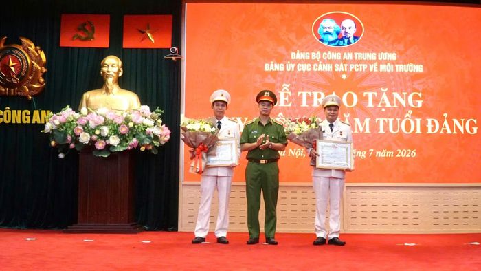 Thừa ủy quyền, Thiếu tướng Thân Văn Hải, Cục trưởng Cục Cảnh sát phòng, chống tội phạm về môi trường trao Huy hiệu 30 năm tuổi Đảng cho 2 đồng chí.
