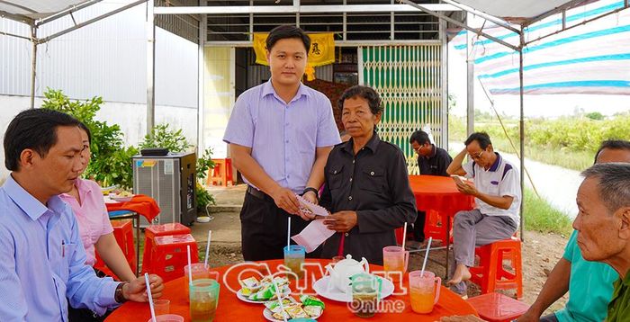  Đại diện Ban Quản lý dự án xã trao hỗ trợ chi phí cho gia đình lo hậu sự.