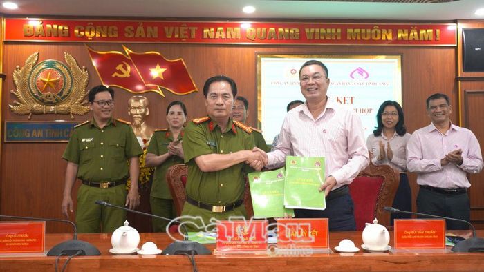 Đại tá Bùi Xuân Khởi, Phó Giám đốc Công an tỉnh và Giám đốc Chi nhánh NHCSXH tỉnh Cà Mau Bùi Văn Thuấn đại diện ký kết chương trình phối hợp giữa hai đơn vị.