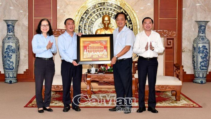Đồng chí Huỳnh Quốc Việt, Phó Bí thư Thường trực Tỉnh ủy Cà Mau và đồng chí Phạm Thành Kiên, Trưởng ban Tổ chức Thành ủy Thành phố Hồ Chí Minh, trao nhau những phần quà lưu niệm, thắt chặt mối quan hệ hợp tác giữa hai địa phương. 