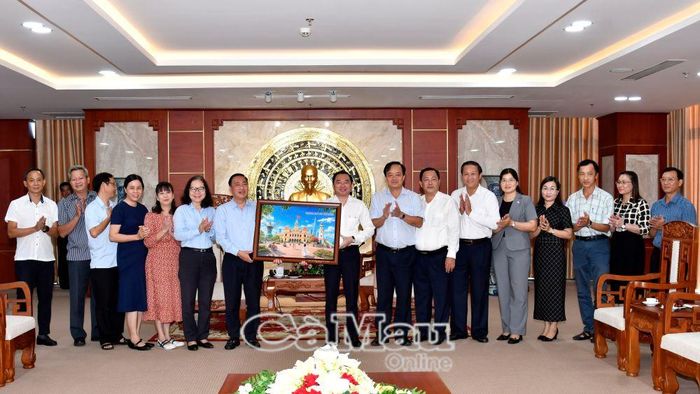 Các đồng chí lãnh đạo và cán bộ hai địa phương tặng quà, chụp ảnh lưu niệm nhân buổi gặp gỡ.
