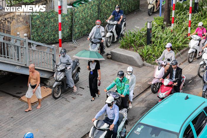 Áp lực giao thông lớn khiến một số người điều khiển xe máy đi lên vỉa hè để vượt qua các điểm ùn ứ trong giờ cao điểm.