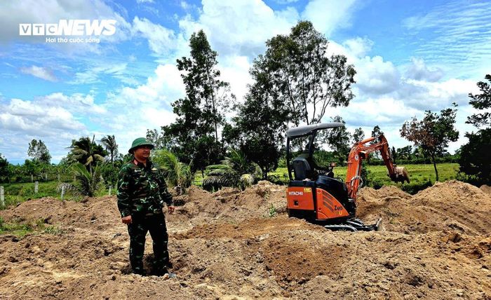 Máy xúc tìm kiếm hài cốt chiến sĩ, liệt sĩ Kiều Đăng Khoa trong vườn nhà ông Tô Điền Lâm.