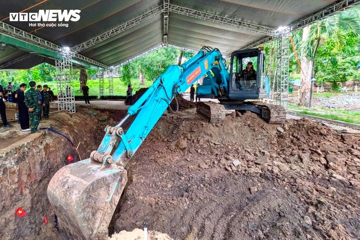 Máy xúc mở rộng vị trí rãnh mộ đầu tiên.