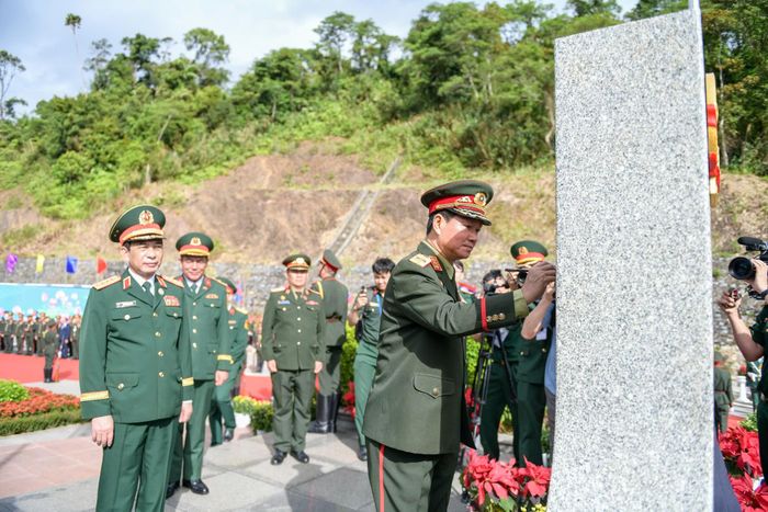 Bộ trưởng Bộ Quốc phòng Việt Nam và Lào tô son cột mốc. Ảnh: Nam Trần