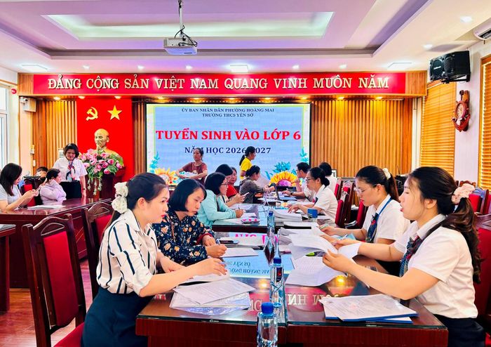 Phụ huynh được giáo viên Trường THCS Yên Sở hỗ trợ đăng ký trực tuyến ngay tại trường. Ảnh: Trần Oanh