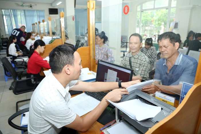 Cán bộ UBND xã Quang Minh hướng dẫn người dân làm thủ tục hành chính. Ảnh: Phạm Hùng