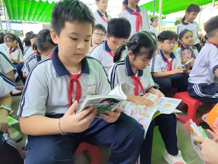 Các em học sinh đọc sách từ chuyến xe “Hành trình Ánh sáng tri thức” của Thư viện Bình Dương