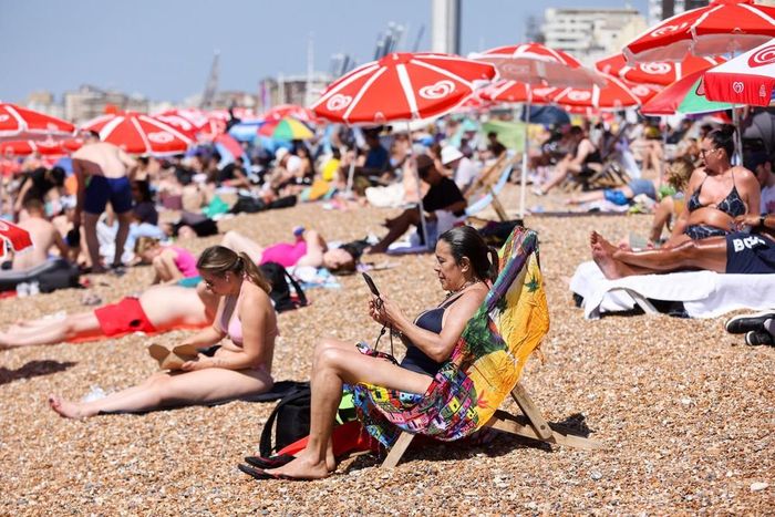 Người dân tránh nóng trên bãi biển ở Brighton, Anh. Ảnh: THX/TTXVN phát